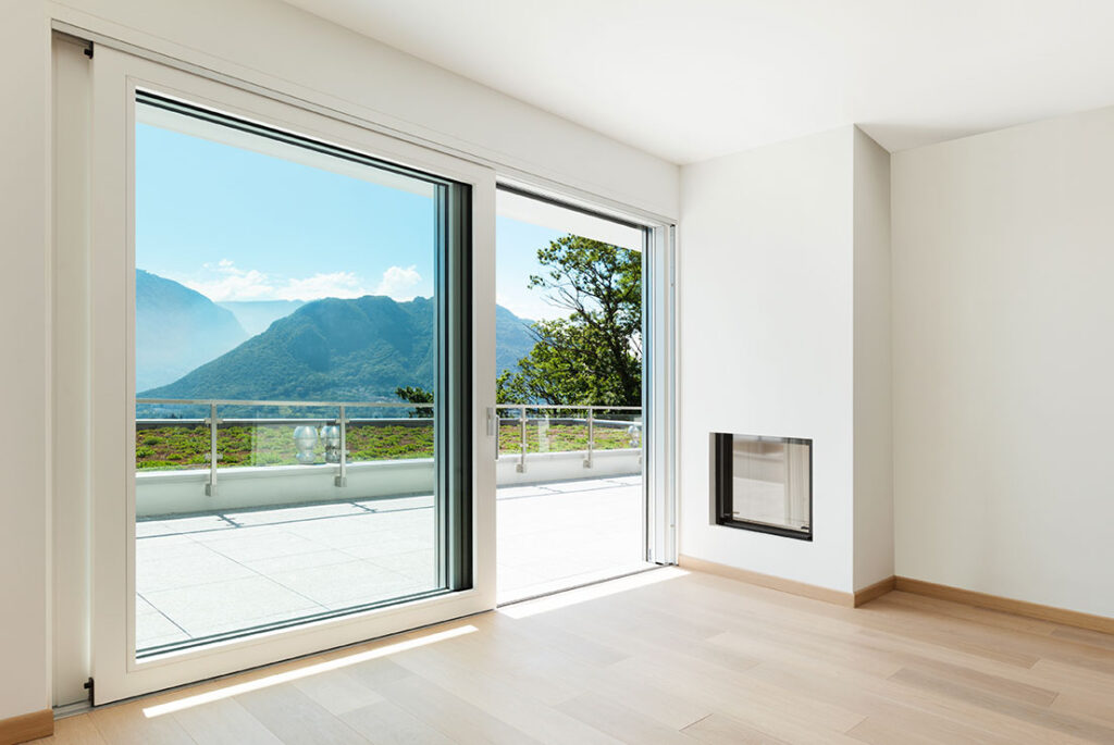 Living Room with hardwood floors and white walls overlooking mountains through a large glass sliding door